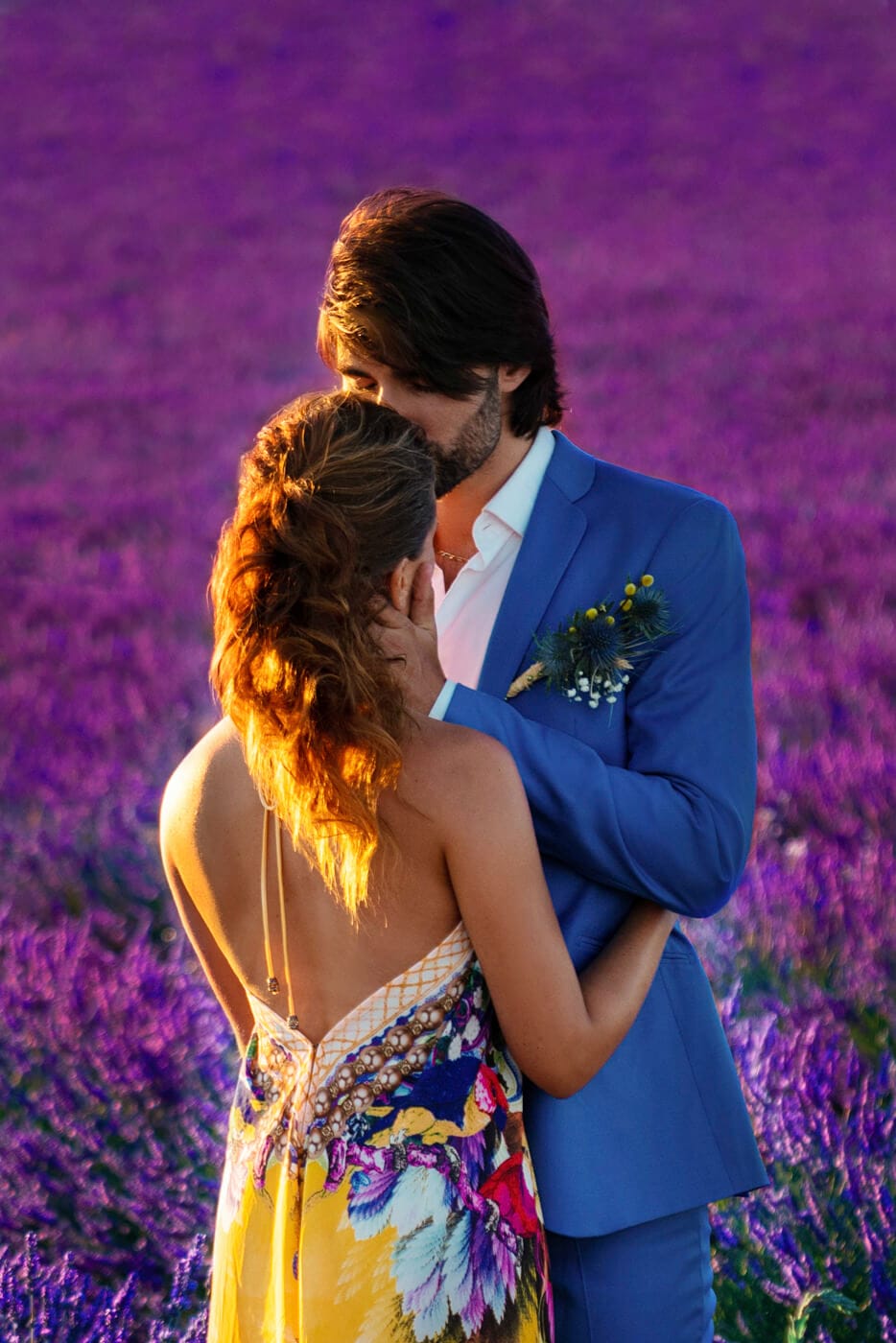Engaged couple softly kissing vibrant lavender fields of Provence, France. Photo taken by famous Destination and NYC engagement photographer.