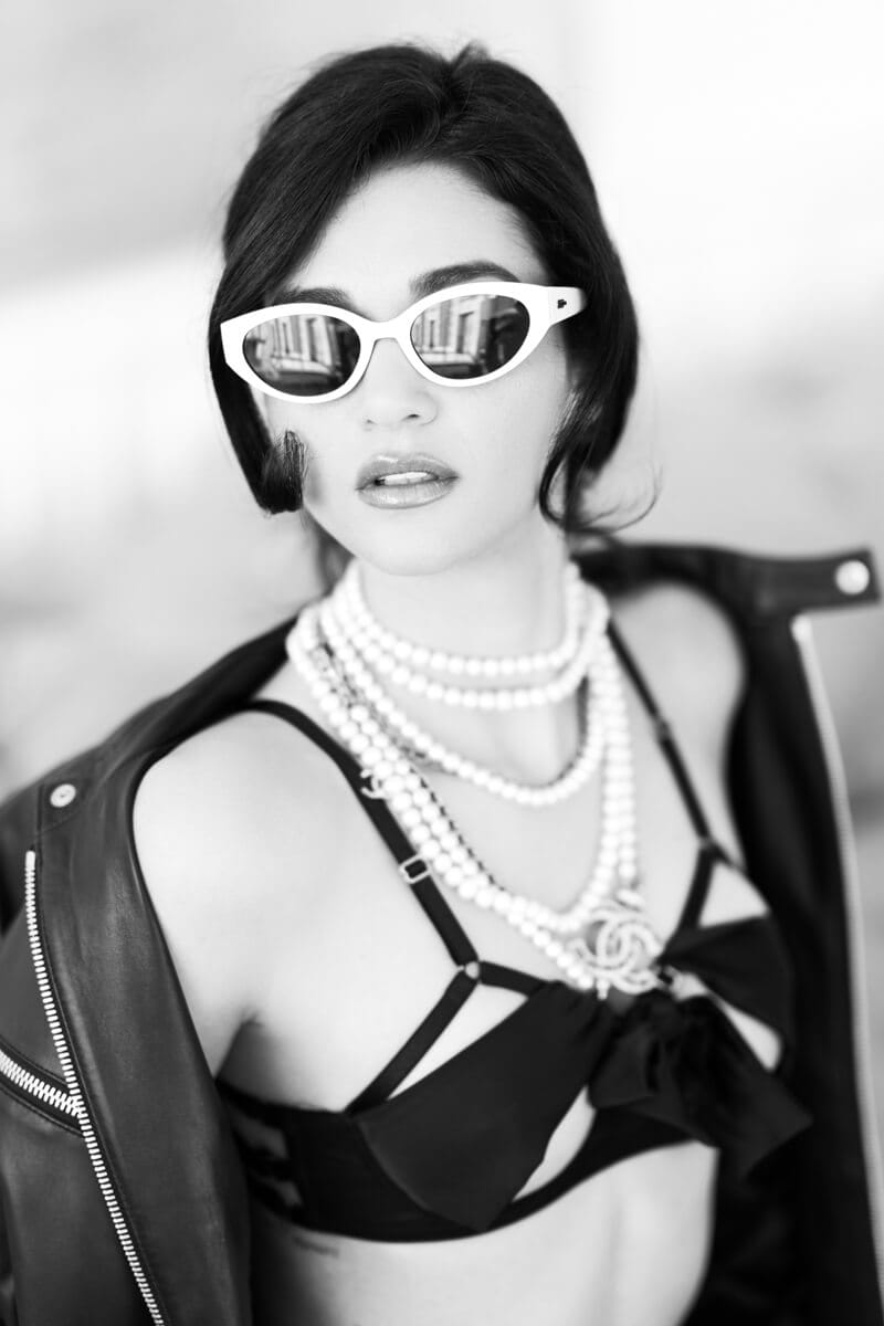 Sensual and tasteful boudoir image featuring a woman with vintage-inspired quintessential New York City sunglasses, pearls, and sexy lingerie.