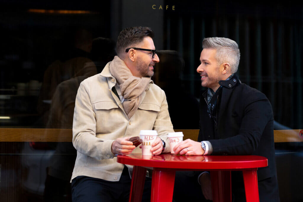 Joyful LGBTQ+ couple sharing a romantic moment over a yummy cafe in Chelsea, NYC.