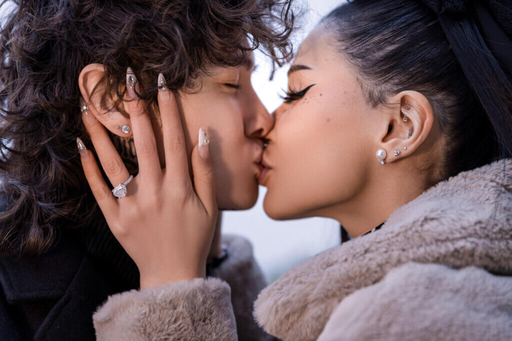 Glamorous celebrity couple engagement session, passionately sealing their love with a heartfelt kiss.