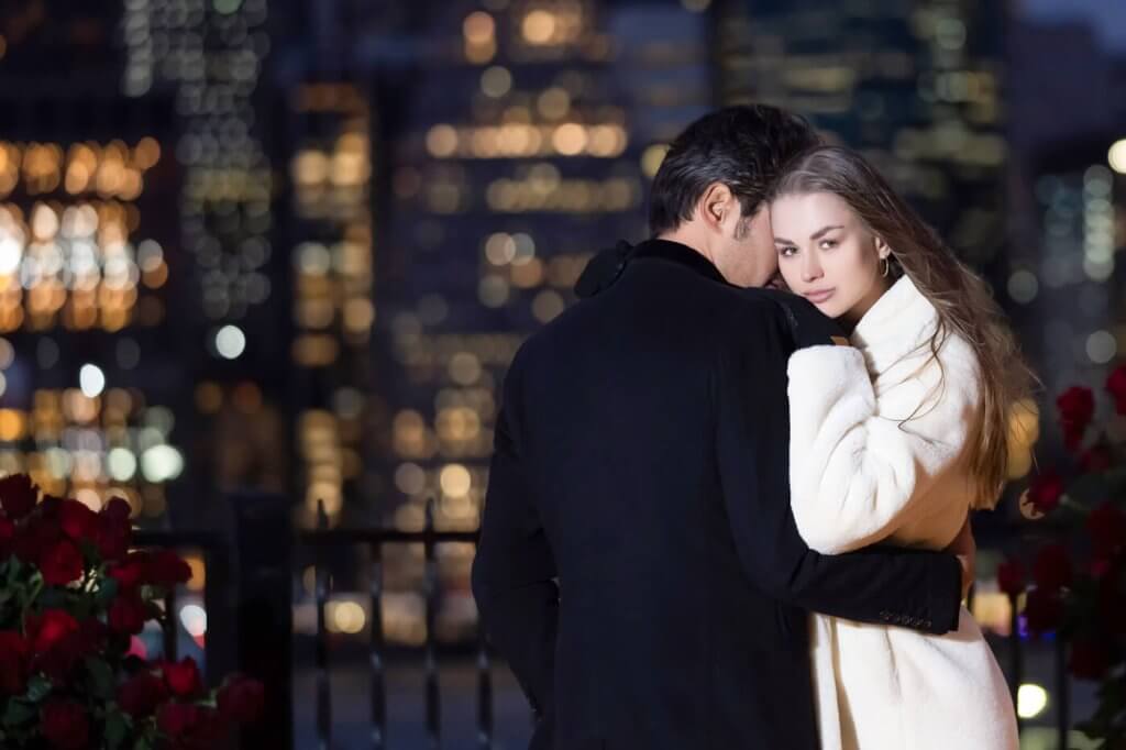 Elegant couple softly embracing moments after their NYC engagement, captured by a secret photographer
