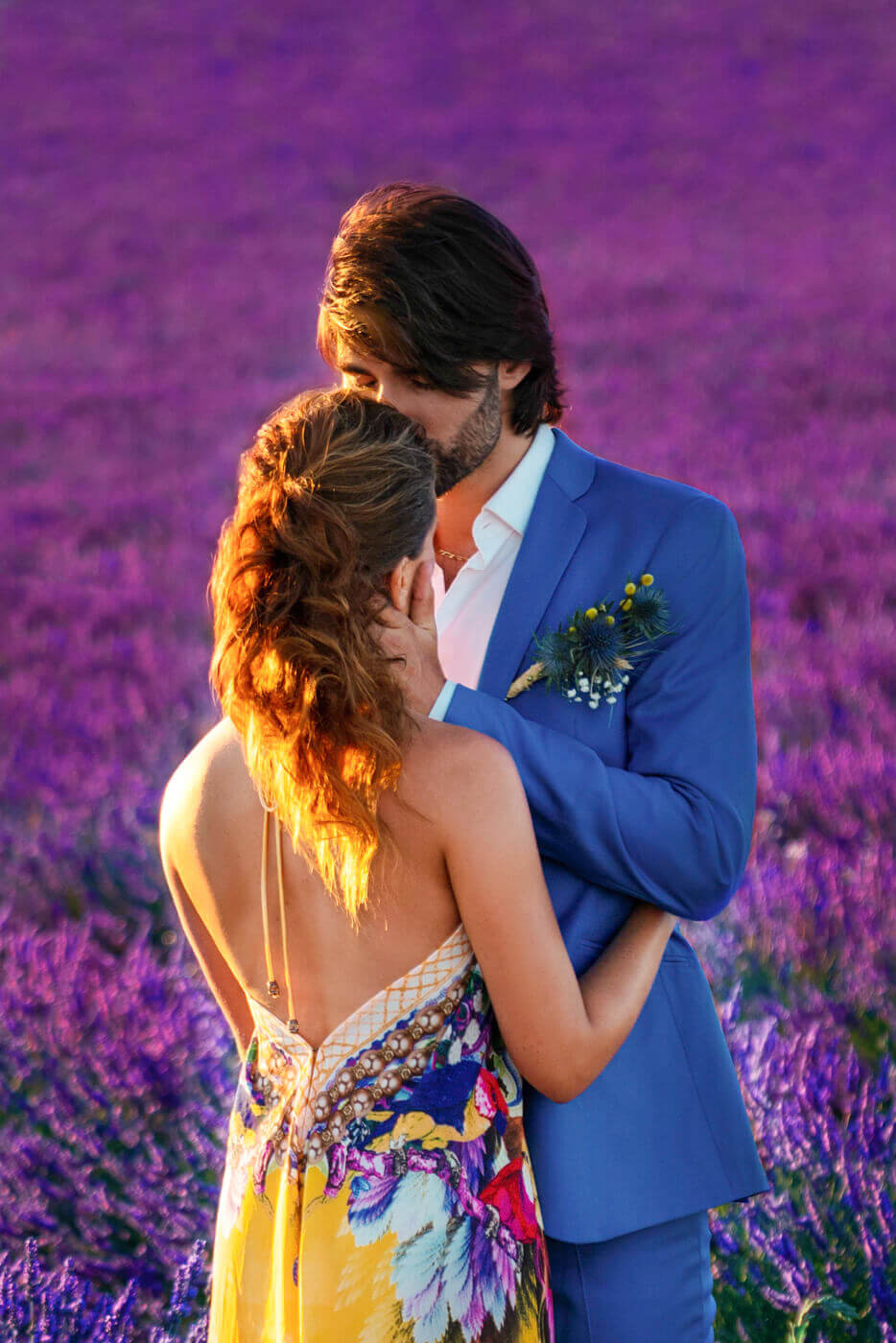 Engaged couple softly kissing vibrant lavender fields of Provence, France. Photo taken by famous Destination and NYC engagement photographer.