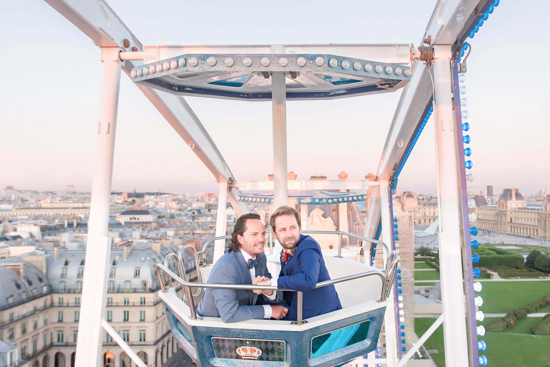 Stylish same-sex couple on big Ferris wheel overlooking Paris in heartfelt engagement photos.